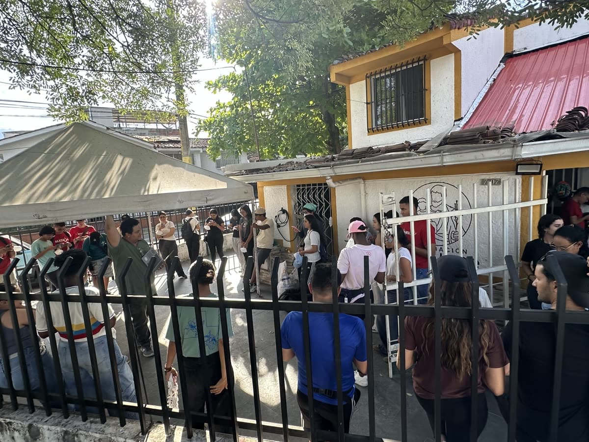 La casita de la Asociación San José convertida en centro de acopio: una carpa en el patio, bultos de ayuda apilados junto a la puerta y un grupo de personas organizándose alrededor.
